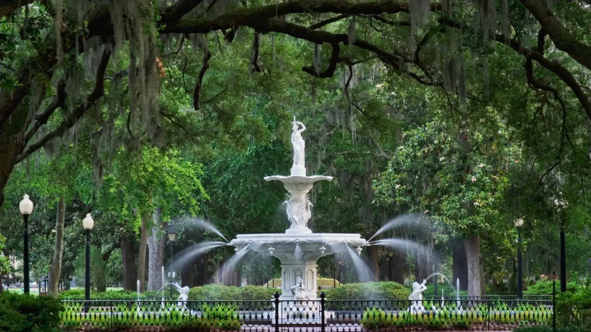 The white Forsyth Park fountain in Savannah framed by live oaks draped in Spanish moss
